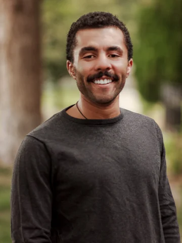 Dr. Calvin Dorsey smiling outdoors in a gray shirt